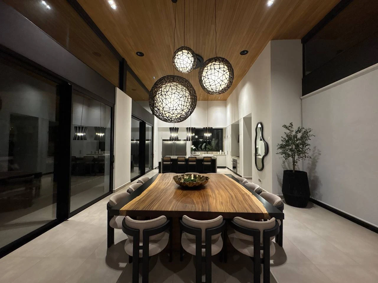Casa 5 at Entroterra, with a timber dining table, sculptural pendant lights and an open kitchen